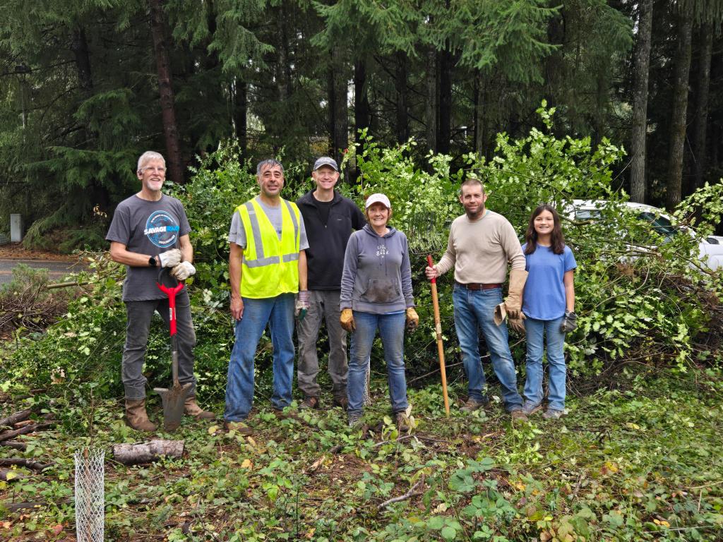 Volunteers in front of a stack of blackberry and holly pulled from the Wilderness Dr (at Boulevard Rd). greenbelt.